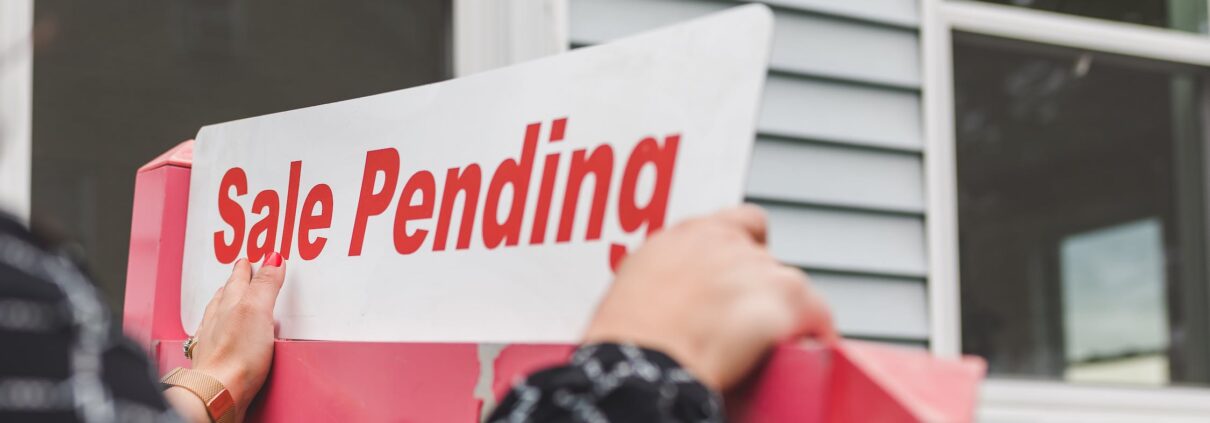 Picture of hands holding a “sale pending” sign