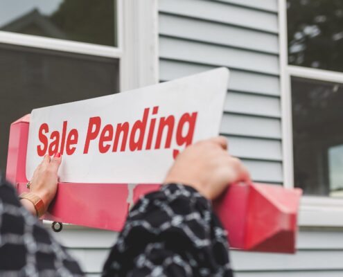 Picture of hands holding a “sale pending” sign